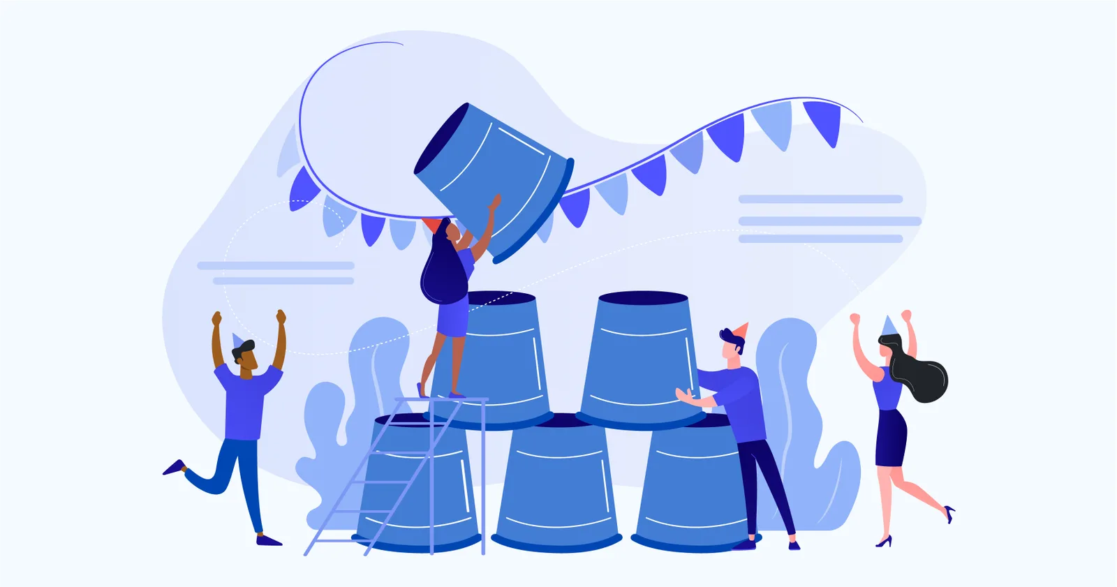 Four colleagues in party hats stacking large cups into a pyramid under bunting, one steadying the top from a stepladder.